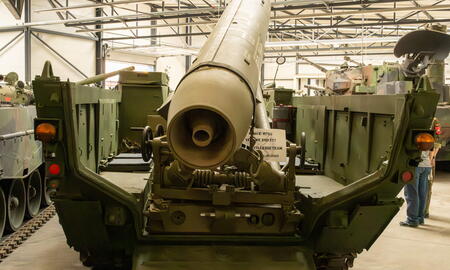 Ein großes Militärfahrzeug mit einer Rakete ist in einer Halle ausgestellt.