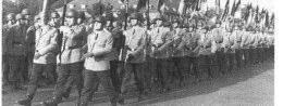 Eine militärische Einheit marschiert in Formation mit Fahnen bei einer feierlichen Zeremonie in der Hindenburg-Kaserne.
