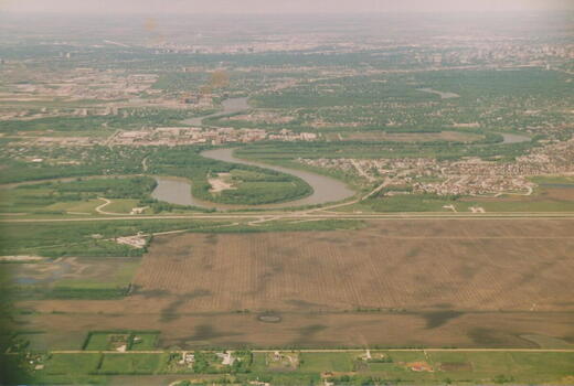 Luftaufnahme von Winnipeg mit Flüssen und Feldern im Vordergrund beim Anflug auf die Stadt im Mai 1991.