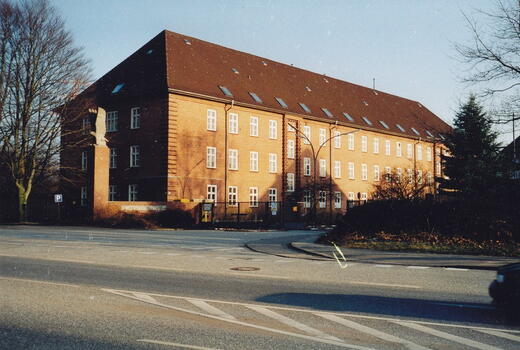 Der Eingang der Bismarck-Kaserne von 1994 zeigt ein rotes Backsteingebäude mit großen Fenstern an einer ruhigen Straße.