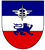 Ein Wappen zeigt einen blauen Löwen auf rotem Grund mit einem blauen und weißen Streifen darüber, gekrönt von einem Symbol.