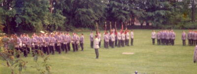 Soldaten stehen in Formation auf einer Wiese, umgeben von Bäumen, während einer feierlichen Indienststellung im Jahr 1981.