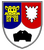 Ein Wappen mit einem gelben Turm auf blauem Grund und einem schwarzen Panzer auf weißem Grund symbolisiert das Panzerbataillon.