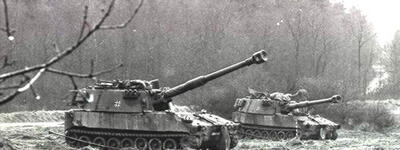 Zwei Panzer stehen 1988 in der Wentorfer Lohe auf einem Feld vor einem dichten Wald, bereit für eine Übung.