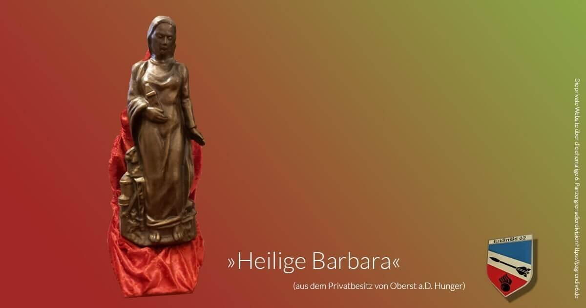 Die Statue der Heiligen Barbara steht auf rotem Stoff vor einem farbigen Hintergrund, mit einem Wappen unten rechts.
