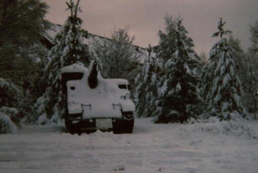 Ein schneebedecktes PZH M7B2 Priest steht in einer verschneiten Waldlandschaft bei dämmerndem Himmel.