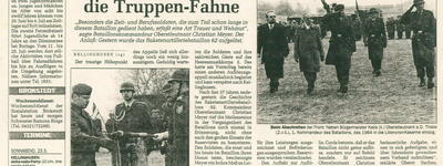Eine Gruppe von Soldaten marschiert während einer Zeremonie, bei der die Truppenfahne mit Trauerflor umhüllt ist.