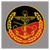 Ein Emblem zeigt ein Anker, Schwingen und gekreuzte Schwerter auf schwarz-rotem Hintergrund, umrahmt von Eichenblättern.