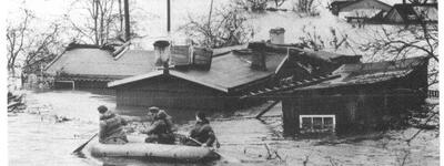 Ein Rettungsboot navigiert durch die überfluteten Straßen von Wilhelmsburg während der Sturmflut von 1962.