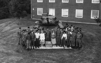 Eine Gruppe von Soldaten und Zivilisten steht vor einem M47-Panzer vor einem Kasernengebäude in der Sachsenwald-Kaserne.