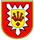 Ein rotes Wappen mit gelbem Schild zeigt ein zentrales Symbol mit drei Pfeilen und einem roten Diamanten.
