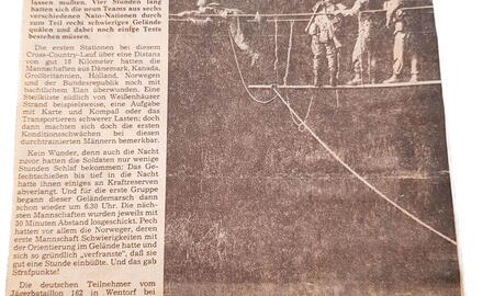 Soldaten überqueren eine improvisierte Seilbrücke bei einem Infanteriewettbewerb, während sie Karten und Kompass nutzen.