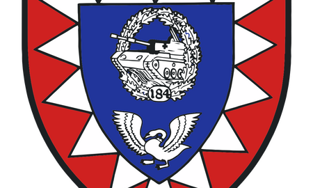Ein Wappen des Panzerbataillons 184 zeigt einen Panzer und einen Adler auf blauem Hintergrund mit rotem Rand.