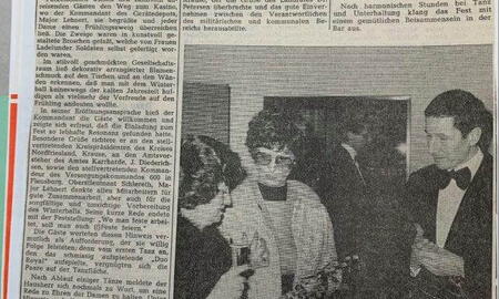 Eine Zeitungsseite mit einem Artikel über einen Winterball in Ladelund zeigt ein Foto von Gästen in festlicher Kleidung.