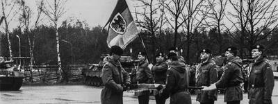 Soldaten des Panzerbataillons 181 stehen mit einer Fahne in Formation auf einem regnerischen Exerzierplatz.