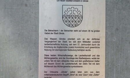 Eine Infotafel in Glinde erklärt die Bedeutung des Stadtwappens und die Entstehung des neuen Stadtteils "Alte Wache".