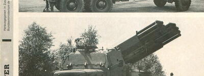 Ein Raketenwerfer des Typs Rak W 110 SF ist auf einem Lkw montiert und wird auf einem offenen Gelände präsentiert.