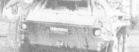 Ein gepanzertes Fahrzeug steht auf einer Wiese, umgeben von Bäumen, und erinnert an historische Modelle von 1959 bis 1993.