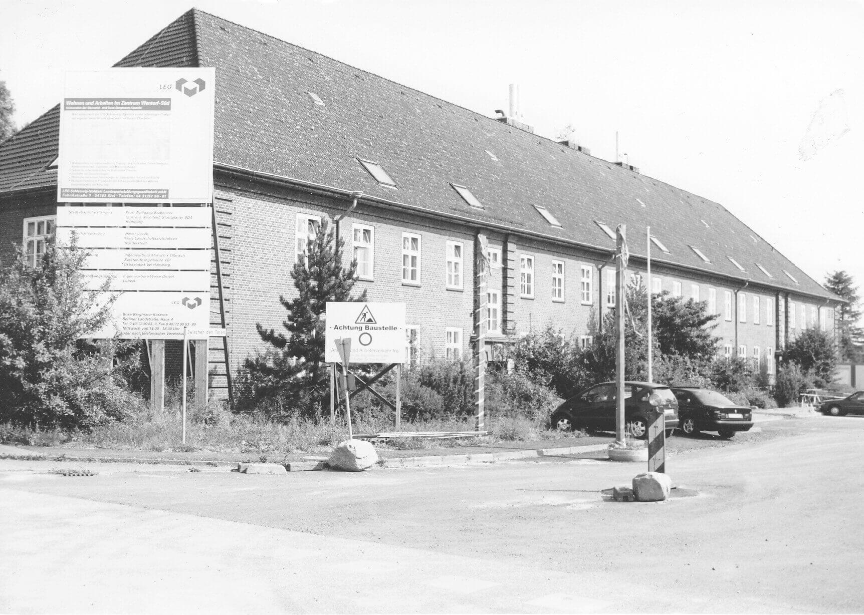 Das Haupttor der Bergmann-Kaserne 1998 zeigt Schilder und Baustellenaktivität während der Konversion des Geländes.