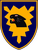 Ein Wappen zeigt einen schwarzen Pantherkopf auf einem gelben, gezackten Hintergrund, umrahmt von einem blauen Schild.