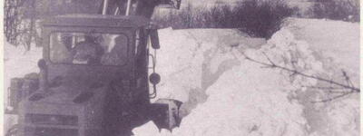 Ein Bulldozer räumt während der Schneekatastrophe 1979 meterhohe Schneemassen von einer verschneiten Straße.
