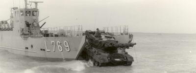 Ein Panzer verlässt 1986 ein Landungsboot während einer amphibischen Übung an einer Kiesküste.