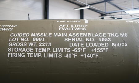 Auf einem olivgrünen Raketenkörper sind technische Informationen und Temperaturgrenzen in weißer Schrift aufgedruckt.