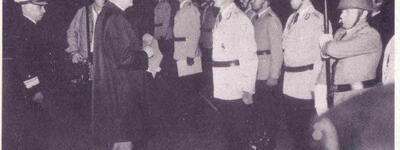 Der Ministerpräsident von Schleswig-Holstein überreicht 1979 ein Fahnenband an eine Reihe uniformierter Soldaten.