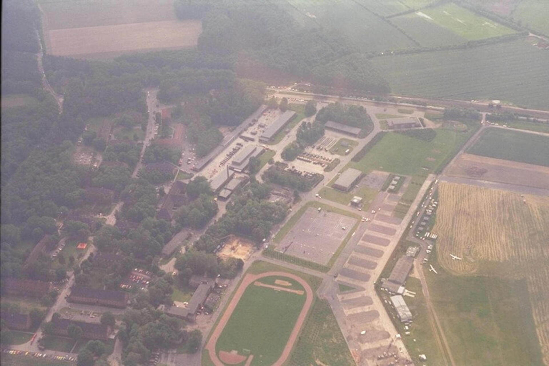 Luftaufnahme der Hanseaten-Kaserne von 1984 zeigt Gebäude, Straßen und umliegende Felder in einer grünen Landschaft.