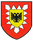 Ein Wappen mit einem schwarzen Adler auf gelbem Schild und einem roten Hintergrund symbolisiert Stärke und Tradition.