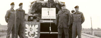 Vier Soldaten posieren vor einem Leopard 1 A5 Panzer mit dem Schild der 4. Kompanie PzBtl 183 auf einer Straße.