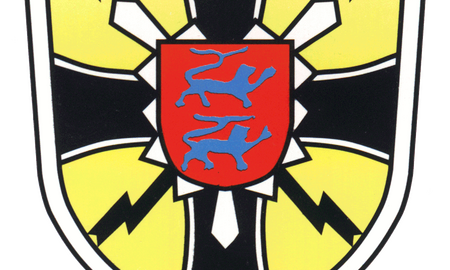 Ein Wappen mit roten Schild und blauen Löwen, umgeben von gelben und schwarzen Blitzmotiven.
