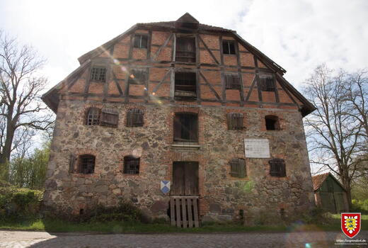 Ein historisches Fachwerkhaus in Lanken steht bei sonnigem Wetter vor einem bewölkten Himmel.