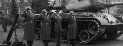 Soldaten salutieren vor einem Panzer aus den Jahren 1956-92 auf einem Kasernengelände.
